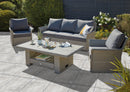 Outdoor Porcelain Tile AK Rose showing the grey concrete style tile being used outdoors. With a grey / brown sofa set.