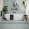 Victorian Tile lifestyle image showing the blue floral tile being used all the way up the wall, down onto the floor behind a bath to create a zoned area