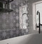 The Opulence Stargazer Smoke Grey tile being used in a bathroom alongside the plain smoke grey opulence tiles, to create a featured backsplash behind a bath.