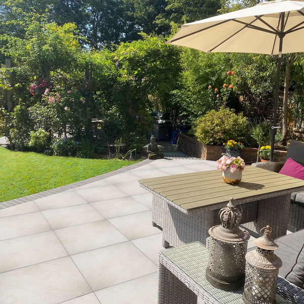 Lifestyle image of the House of Mosaics Grove outdoor porcelain tile being used to create an outdoor living space in the garden, complete with a table and chair set