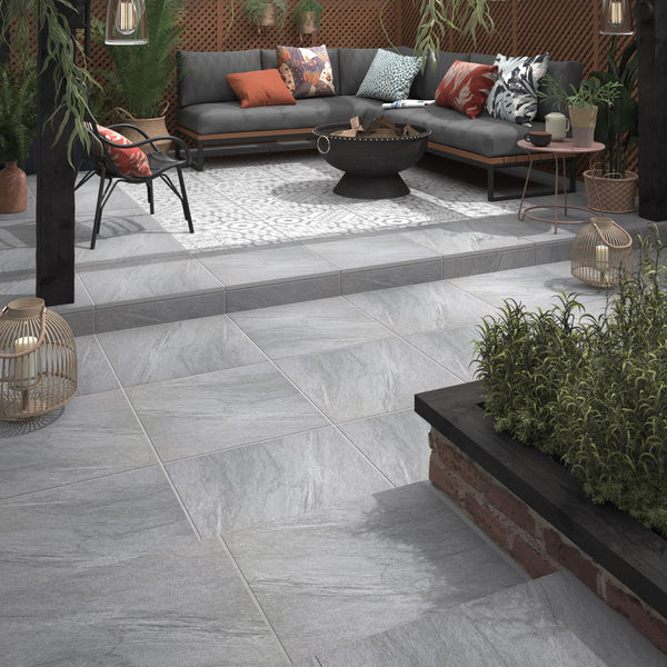 A lifestyle image of the House of Mosaics Nordic Outdoor Porcelain Tile in light grey, used in an outdoor seating area