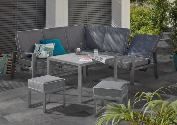 Slate outdoor porcelain tile lifestyle image showing the dark coloured porcelain tile being used with a grey seating area in the garden
