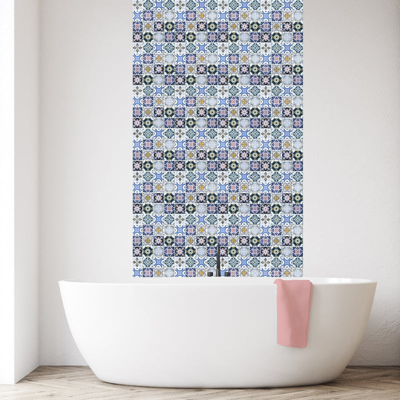 A lifestyle image of the Porto Mosaic, with a blue, yellow, white and pink Moroccan inspired pattern, in situ behind a bath. 