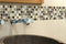 Tuscon Small Mosaic Lifestyle Images showing the mosaic being used as a border in a bathroom behind the sink