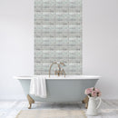 Darcy mosaic tile lifestyle image showing a zoned mosaic wall area in a bathroom. With a stand alone grey bathtub and muted pink flowers
